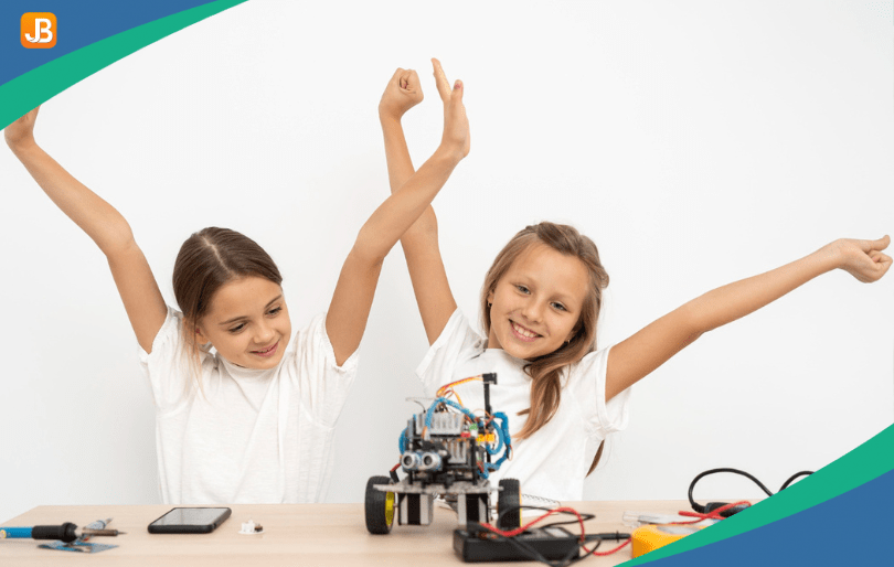 Two girls smile and are excited after building robots together