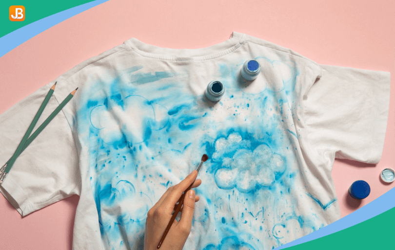 A camper painting a T-shirt with colorful designs