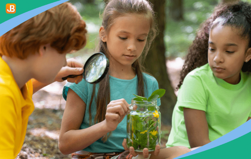 Children use magnifying glasses to explore nature, observing plants and textures closely