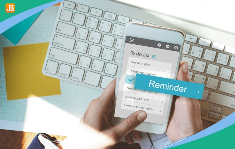 A hand holding a phone displaying the word 'Reminder.