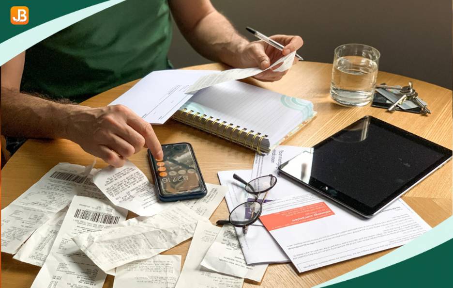 A man enters payment details in a notebook, surrounded by receipts, highlighting the inefficiencies of manual fee management.