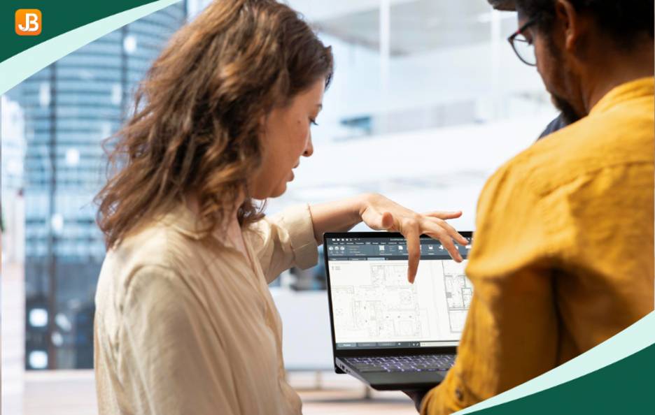 Two people discussing something on a laptop, representing the benefits of automation in class registration.